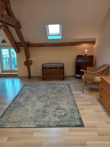 un grand salon avec un tapis et un piano dans l'établissement Badger Cottage, à Salagnac