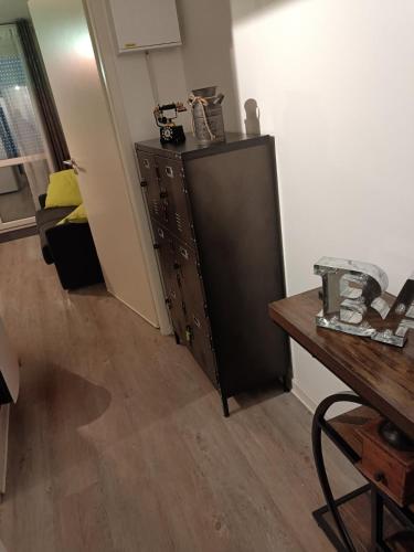 a room with a black cabinet and a table at Le Cozy du Poli, Résidence Le Haut des Lacs in Xonrupt-Longemer