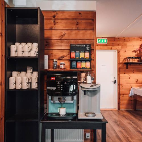 a coffee shop with a coffee maker on a table at Blue View Cabins in Reykholt