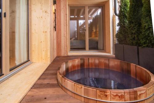Chalet Le Rokh في Landry: حوض خشبي كبير موضوع على سطح بجوار نافذة