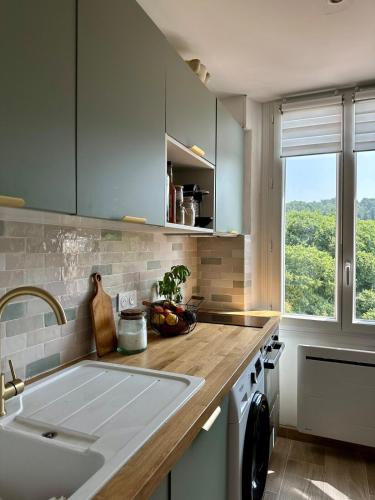 - une cuisine avec un évier et un comptoir avec une fenêtre dans l'établissement Nid Provençal - cœur de Village, à Callas