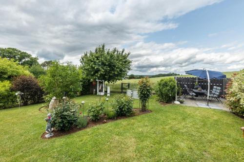 a garden with a table and an umbrella at Ferienwohnung Landblick in Homberg
