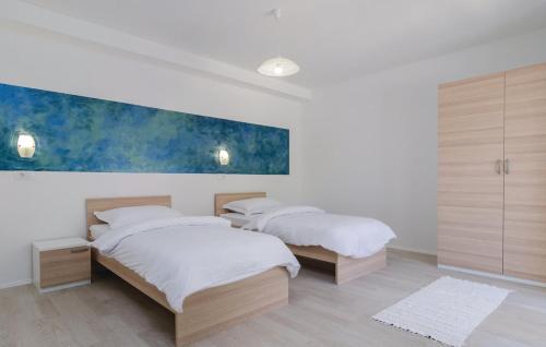 - 2 lits dans une chambre avec un tableau mural dans l'établissement Apartmani Monaco, à Ploče