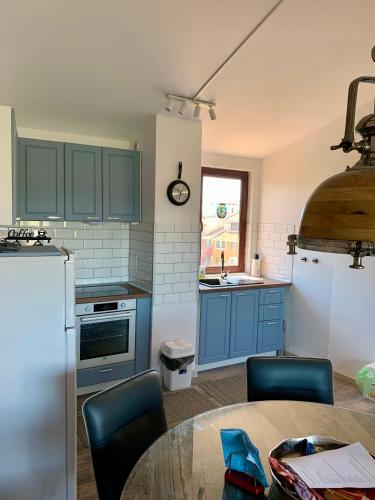 a kitchen with blue cabinets and a table with chairs at Seaview Holiday - Черноморска почивка in Aheloy