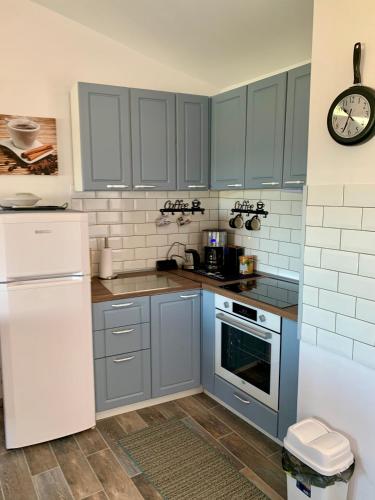 a kitchen with blue cabinets and a white refrigerator at Seaview Holiday - Черноморска почивка in Aheloy