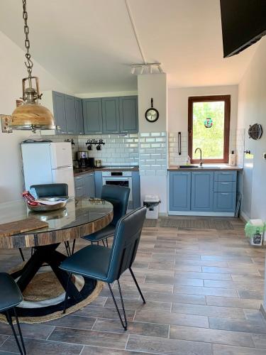 a kitchen with blue cabinets and a table and chairs at Seaview Holiday - Черноморска почивка in Aheloy