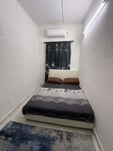 a small bedroom with a bed in a room at Mom House in Ipoh