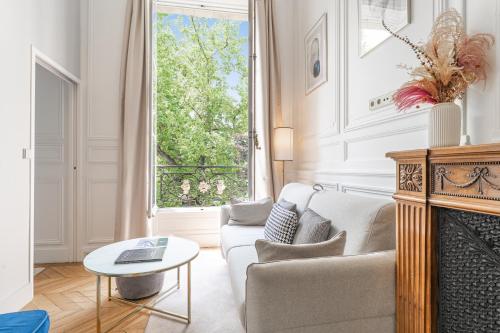 a living room with a couch and a fireplace at Maison Labruyère Bordeaux - Jardin Public in Bordeaux