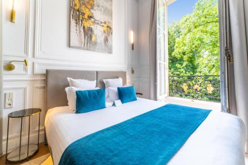 a bedroom with a large bed with a large window at Maison Labruyère Bordeaux - Jardin Public in Bordeaux
