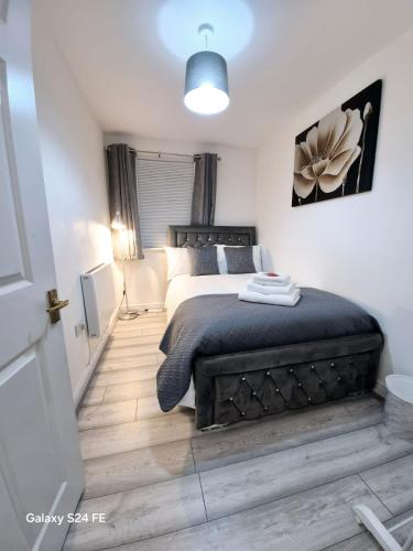 a bedroom with a large bed with a black bedspread at Robinhuts Views Apartments in London