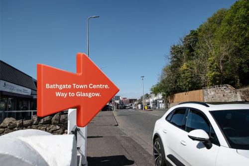 an orange arrow sign next to a white car at Penthouse at the White House near Edinburgh in Bathgate