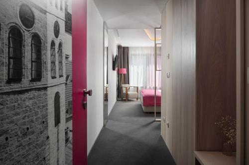a corridor of a hotel room with a pink wall at Hotel Colors Inn in Sarajevo