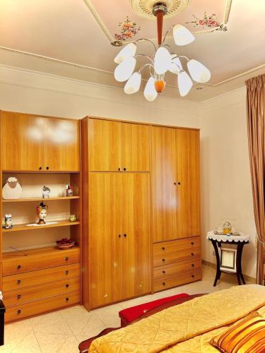 a bedroom with a ceiling fan and wooden cabinets at CASA MILAN DA mariella in Palo del Colle