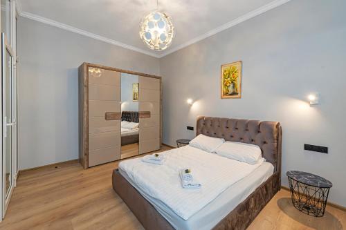 Un dormitorio con una cama y un espejo grande. en The Comfort Apartment #2 by Polo Apartments, en Kaunas