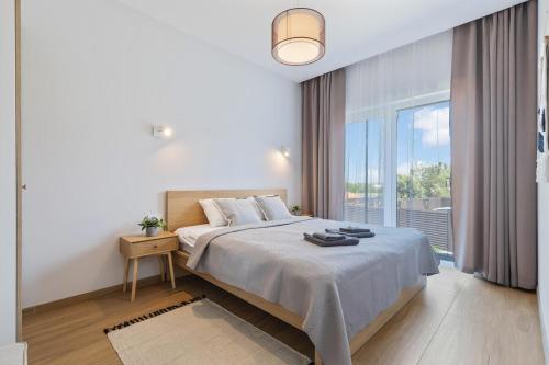 ヴィリニュスにあるNiwaki Sodai No 1 by URBAN RENTの大きなベッドと大きな窓のある寝室