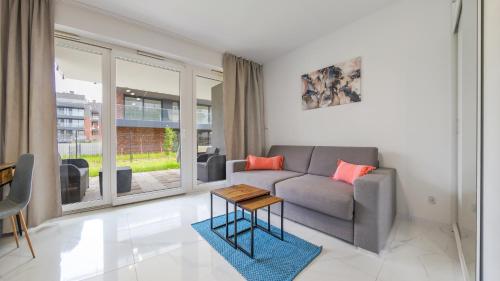 a living room with a couch and a table at Ukiel, Sun & Snow in Olsztyn