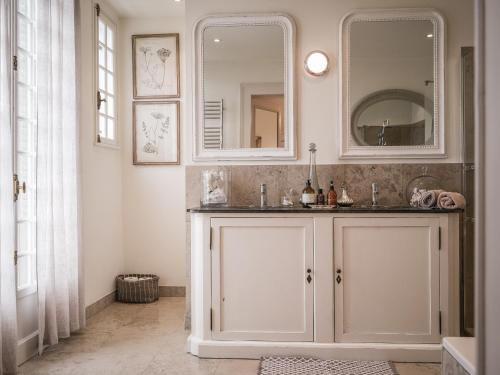 une salle de bain avec un lavabo et un miroir dans l'établissement Venez Chez Vous La Villa des Pensières, à Veyrier-du-Lac
