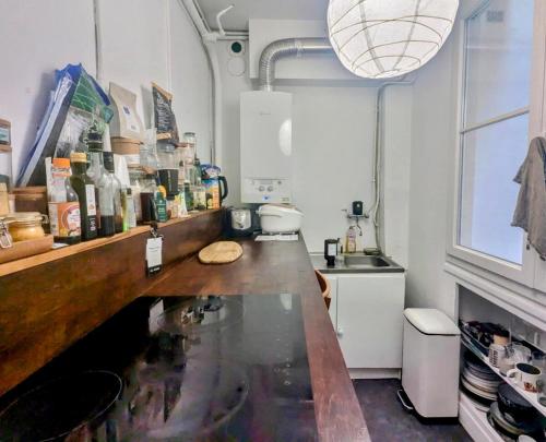 une cuisine avec un comptoir et un évier dans l'établissement Spacieux appart cosy 2 chambres, à Paris
