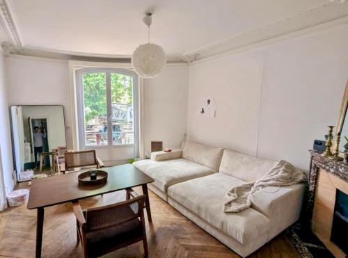 un salon avec un canapé et une table dans l'établissement Spacieux appart cosy 2 chambres, à Paris