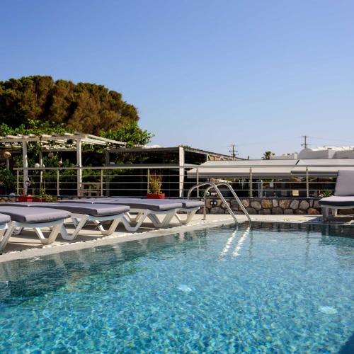 una piscina con sedie e uno scivolo d'acqua di Akis Hotel a Kamari