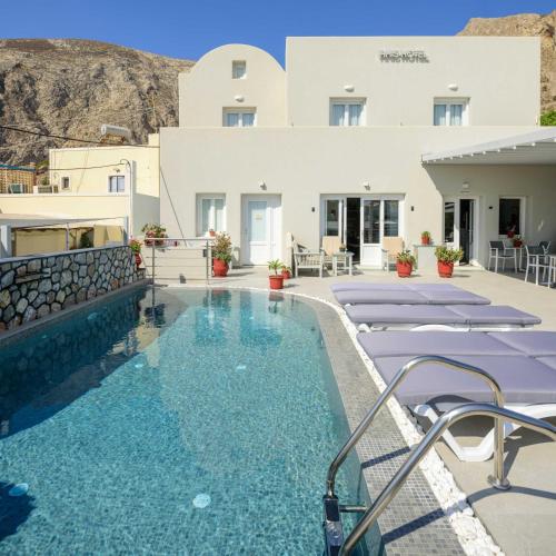 un hotel con piscina di fronte a un edificio di Akis Hotel a Kamari