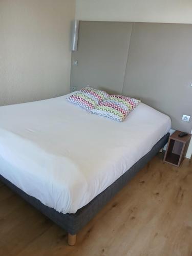 un lit avec deux oreillers dessus dans une chambre dans l'établissement Campanile Orléans Ouest ~ La Chapelle-St-Mesmin, à La Chapelle-Saint-Mesmin