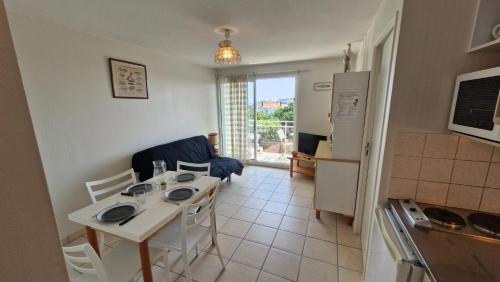 une cuisine et une salle à manger avec une table et un réfrigérateur dans l'établissement Royan - APPARTEMENT VUE MER - à SEULEMENT 300m PLAGE et COMMERCES, à Royan