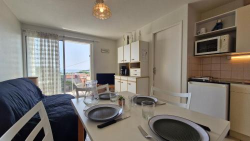 d'une cuisine et d'un salon avec une table et des assiettes. dans l'établissement Royan - APPARTEMENT VUE MER - à SEULEMENT 300m PLAGE et COMMERCES, à Royan