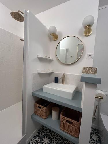 une salle de bain avec un lavabo et un miroir dans l'établissement un rêve à la mer, à Saintes-Maries-de-la-Mer
