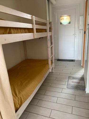 Cette chambre comprend 2 lits superposés et une porte. dans l'établissement Studio cosy à 300 m de la plage 1 à 4 pers, à La Celle-sous-Gouzon