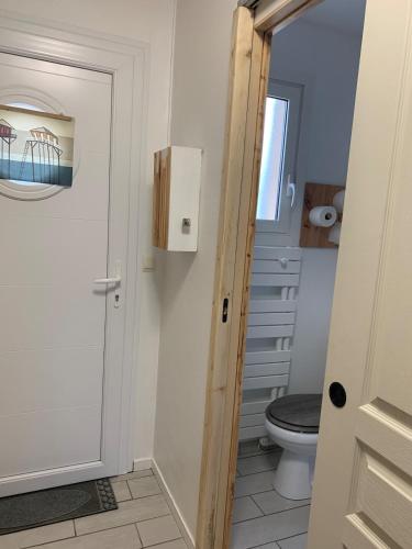 - une salle de bains avec des toilettes à côté d'une porte dans l'établissement Studio cosy à 300 m de la plage 1 à 4 pers, à La Celle-sous-Gouzon