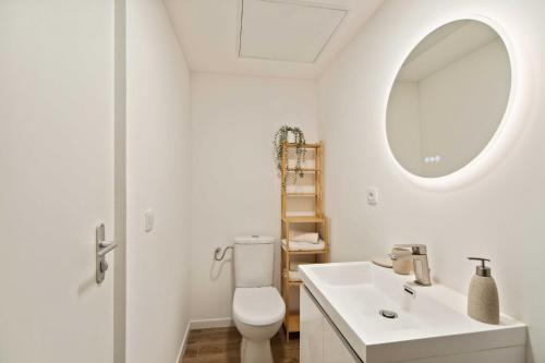une salle de bain blanche avec un lavabo et un miroir dans l'établissement Elegant appt- AC- 1BR 2P - Centre St Tropez, à Saint-Tropez