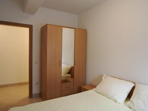 a bedroom with a bed and a cabinet with a mirror at Villa Njavro in Neum