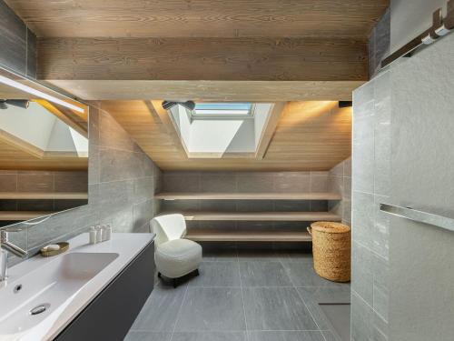 La salle de bains est pourvue d'un lavabo, de toilettes et d'une lucarne. dans l'établissement Duplex à Megève avec spa, piscine, salle de sport et cheminée - FR-1-569-32, à Megève