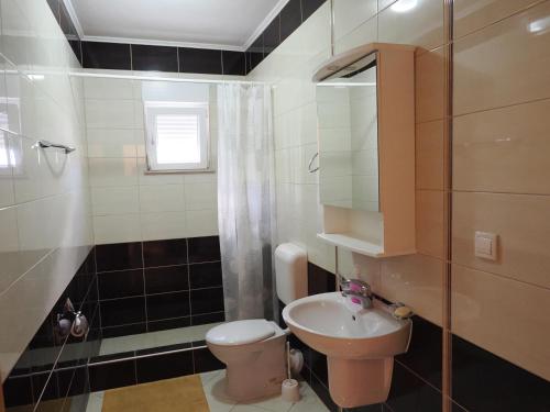a small bathroom with a toilet and a sink at Villa Njavro in Neum