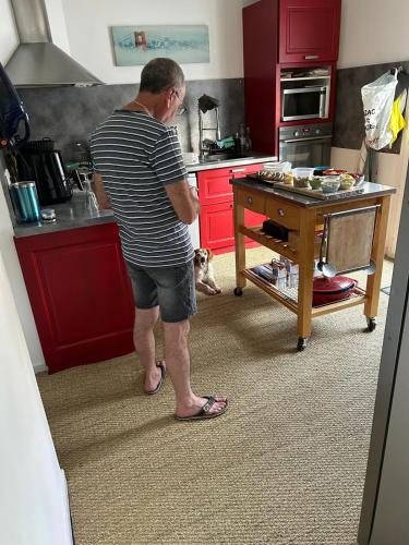 un homme debout dans une cuisine avec un chien dans l'établissement Villa avec piscine spacieuse, à Saint-Jean-de-Védas
