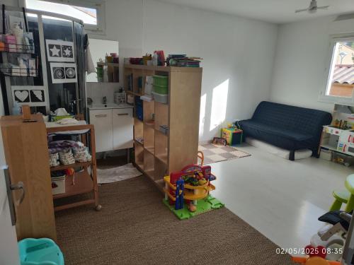 un salon avec un canapé bleu et une cuisine dans l'établissement Villa avec piscine spacieuse, à Saint-Jean-de-Védas