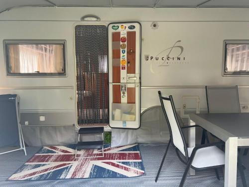 a dining room with a table and chairs in a trailer at Camping Alex in Cadenazzo