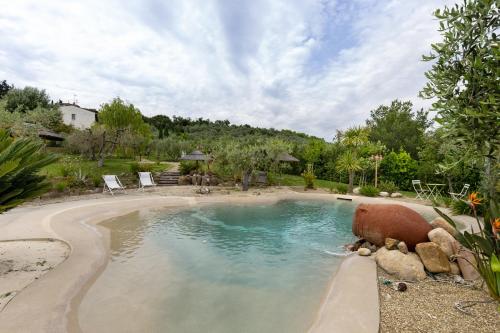 a swimming pool in a yard with chairs in it at Tenuta Virgilio Colline del Chianti in Tavarnelle in Val di Pesa