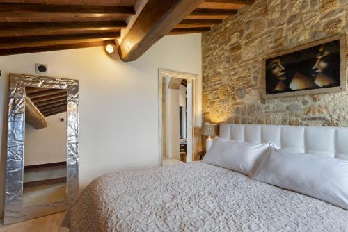 a bedroom with a bed and a stone wall at Tenuta Virgilio Colline del Chianti in Tavarnelle in Val di Pesa