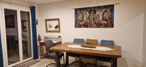 une table de salle à manger avec des chaises et un tableau au mur dans l'établissement Family cocoon near the sea, à Sanary-sur-Mer