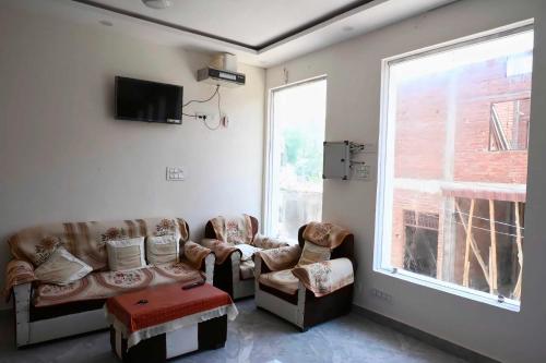 a living room with two couches and a window at Home O Maa Radhika inn in Ayodhya
