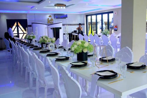 a long white table with white chairs and flowers at Apex Boutique Hotel in Estcourt