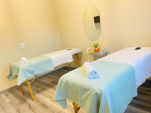a hospital room with two beds and a mirror at Apex Boutique Hotel in Estcourt