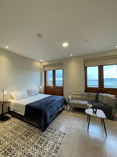 a bedroom with a bed and a couch at AmazINN Places Casa Fortaleza in Panama City