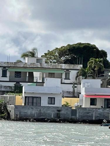 a house on the shore of a body of water at Ashan Luxury Seafront Villa 1 in Grande Rivière Sud Est