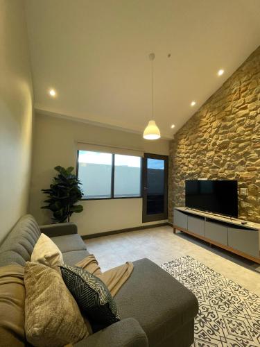 a living room with a couch and a flat screen tv at AmazINN Places Casa Fortaleza in Panama City