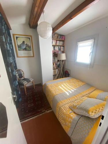 une chambre avec un lit, une chaise et une fenêtre dans l'établissement Maison dans la pinède, à Lacanau