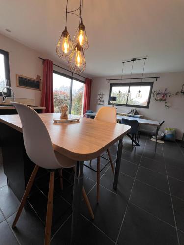 une salle à manger avec une table et des chaises en bois dans l'établissement Maison proche circuit du Mans, à Guécélard