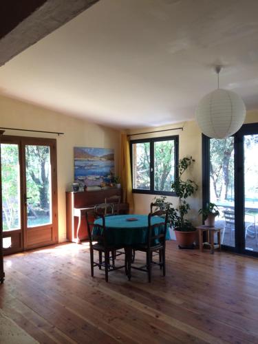 un salon avec une table et des chaises dans l'établissement Maison en pleine nature, à Aniane